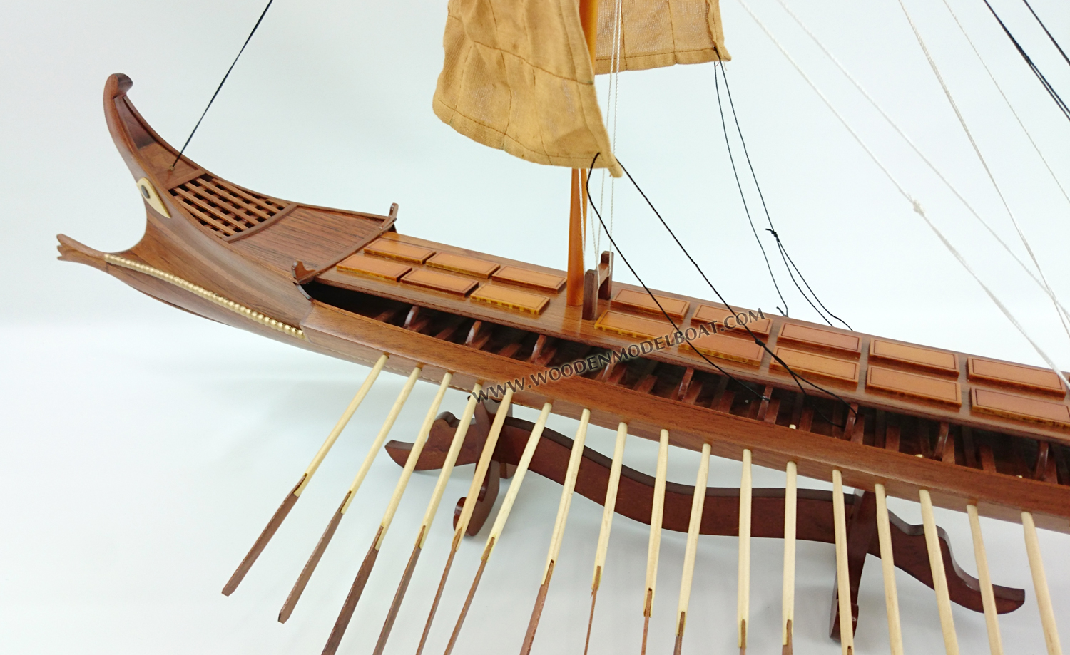 Bireme, ship with two series of oars in each side, was the precursor of trireme and forms the in-between link evolution from pentikoro to subsequent ships. Biremes were made with thirty or fifty oars and the dimensions of these ships are between: 18-22m length, 3-4 m width, 22 tones displacement and the length of the oars 4-6 m. The most famous biremes were made in Samos from tyrant Polykrates and were named samaines. It was a special type of biremes, made in such a way so that could be used as a tanker and as a battle ship in the same time. For greater stability of the ship the Phoenicians lowered the crinolines (platforms where oarsmen sat). A massive bronze covered battering ram was the main weapon of this narrow high speed bireme. The traditional removable rig was typical. A decorative poop extremity of stern was abruptly bent, similarly to a tail of a scorpion, and the balustrade of the battle platform was covered with the shields of warriors for reinforcement. Phoenicians were considered as the best seamen of the time and many ancient states frequently used them as mercenaries. The bireme displayed is an in-between type made in 450 B. C. The first battle samaines were made in Samos in 250-400 B. C. The effigy-model is a pentikontors bireme, which width is up to 4 meters, united deck, powerful ram-beak and big square sail.